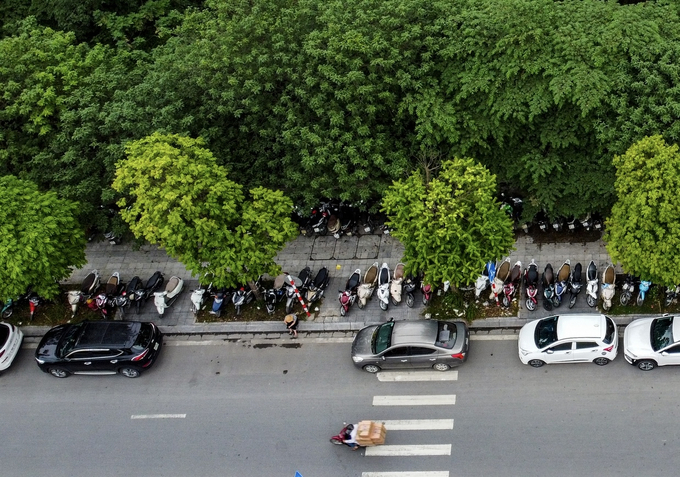 Xe máy, ô tô xếp hàng dài cả trên vỉa hè lẫn dưới lòng đường. Xe máy, ô tô xếp hàng dài cả trên vỉa hè lẫn dưới lòng đường.