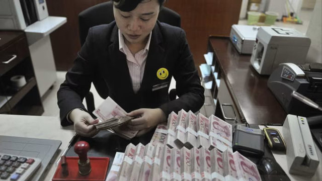 Một nh&acirc;n vi&ecirc;n đếm tiền tại một chi nh&aacute;nh của China Merchants Bank, nơi đ&atilde; thay đổi quyết định chỉ định PwC Trung Quốc kiểm to&aacute;n c&aacute;c t&agrave;i khoản năm 2024. (Ảnh: Reuters)