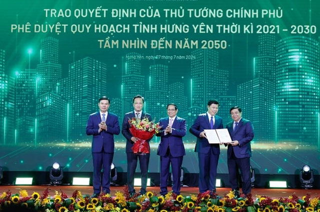 Thủ tướng Phạm Minh Ch&iacute;nh tặng hoa ch&uacute;c mừng l&atilde;nh đạo tỉnh Hưng Y&ecirc;n sau khi quy hoạch tỉnh được c&ocirc;ng bố. Ảnh: Nhật Bắc/VGP