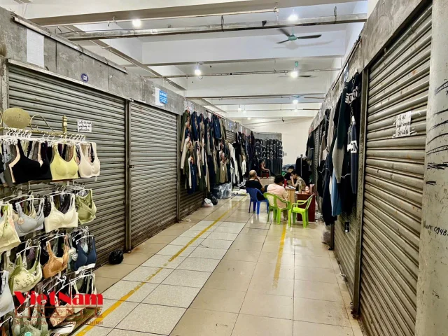 B&ecirc;n trong khu chợ cũng vắng vẻ, nhiều cửa h&agrave;ng đ&oacute;ng cửa. Những kiot mở h&agrave;ng cũng kh&ocirc;ng c&oacute; kh&aacute;ch, ế ẩm.