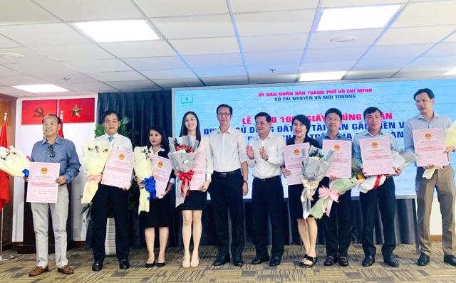 Đại diện doanh nghiệp l&ecirc;n nhận sổ "hồng tượng trưng" từ Gi&aacute;m đốc sở TN&amp;MT Nguyễn To&agrave;n Thắng